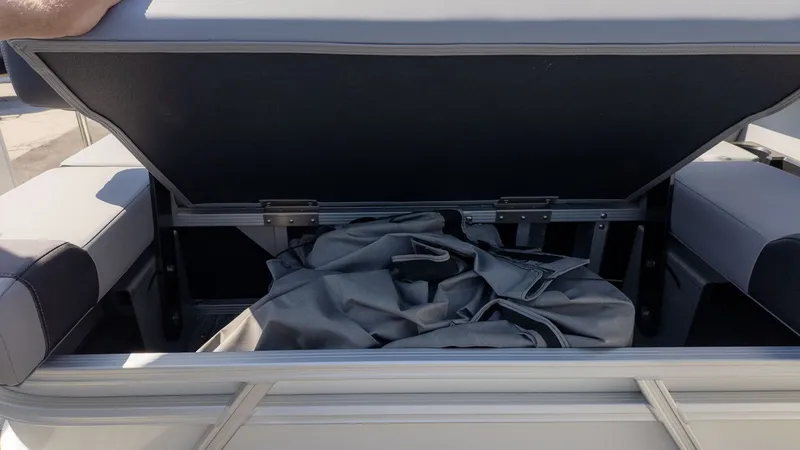 Slide: The Image of An open storage compartment on a boat with gray fabric inside. - 5