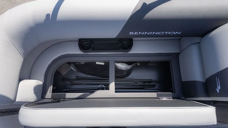 Slide: The Image of The image shows the storage compartment of a Bennington 21 S Swingback boat with gray upholstery. - 12