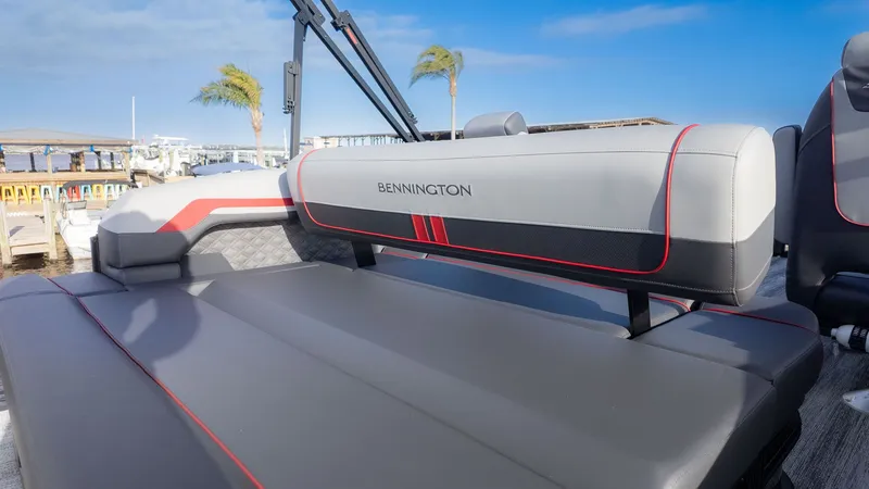 Slide: The Image of Bennington 22 S Swingback 2026 with gray upholstery and red accents, docked at a marina. - 5