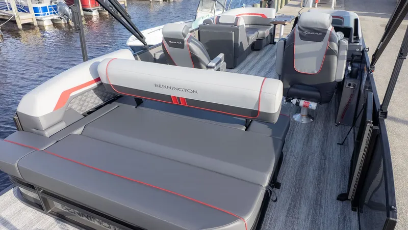 Slide: The Image of The image shows the interior of a Bennington 22 S Swingback pontoon boat with gray and red seating. - 3