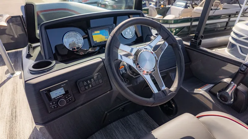 Slide: The Image of The image shows the helm of a Bennington 22 S Swingback boat with modern instruments. - 16