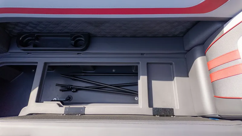Slide: The Image of An open storage compartment on a boat with rods and cup holders. - 15