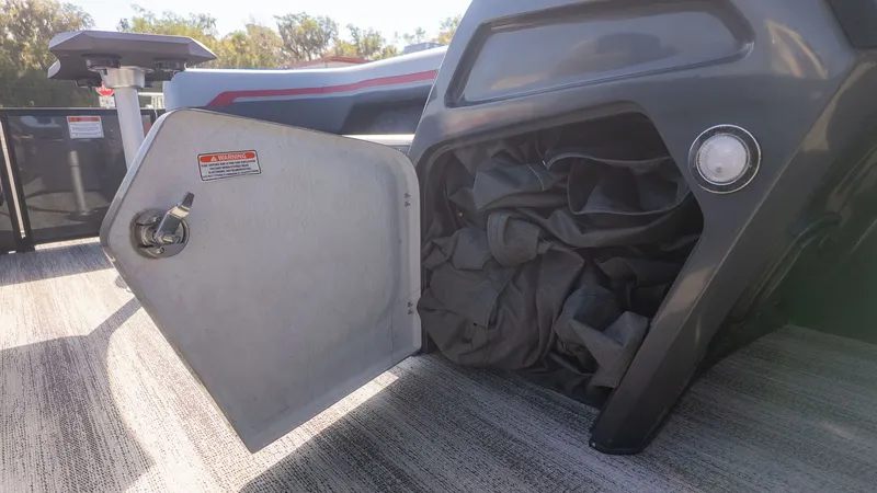 Slide: The Image of An open storage compartment on a boat with gray fabric inside. - 10