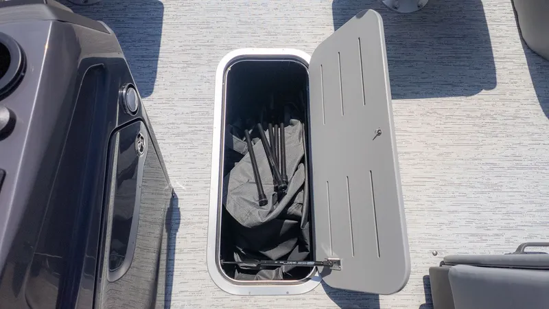 Slide: The Image of An open storage compartment on a boat with gray flooring. - 13