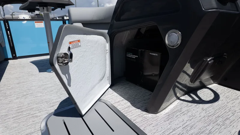 Slide: The Image of An open storage compartment on a modern boat with gray flooring and a blue wall. - 19