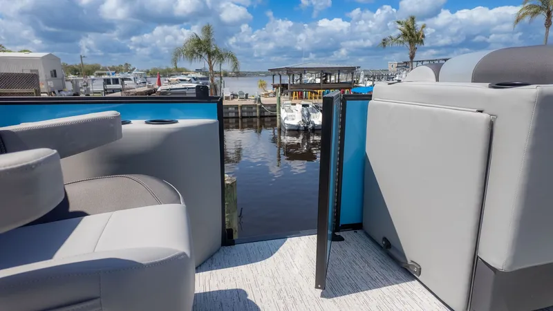 Slide: The Image of The image shows the deck of a Bennington 22 S STERN RADIUS boat overlooking a marina. - 11