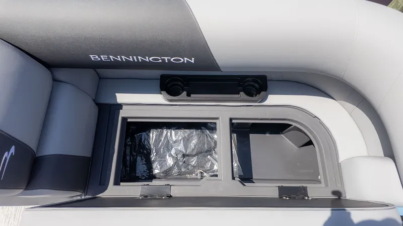 Slide: The Image of Interior view of a Bennington boat with gray upholstery and a storage compartment. - 15