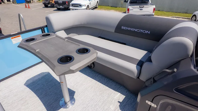 Slide: The Image of Bennington 22 S STERN RADIUS 2026 with gray seating area and table with cup holders. - 16