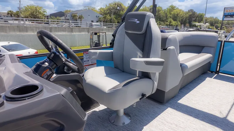 Slide: The Image of The image shows the cockpit of a Bennington 22 S STERN RADIUS boat with a gray captain's chair. - 19