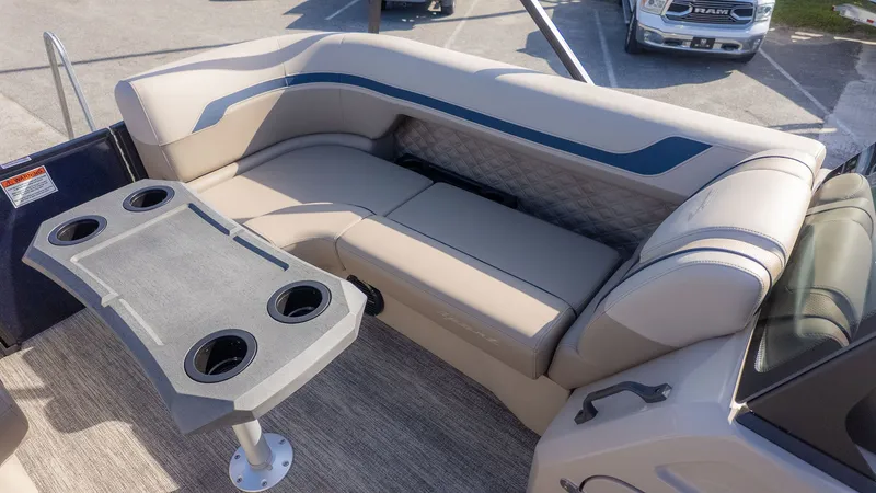 Slide: The Image of Interior of a 2026 Bennington 22 S STERN RADIUS with beige seating and a table with cup holders. - 13