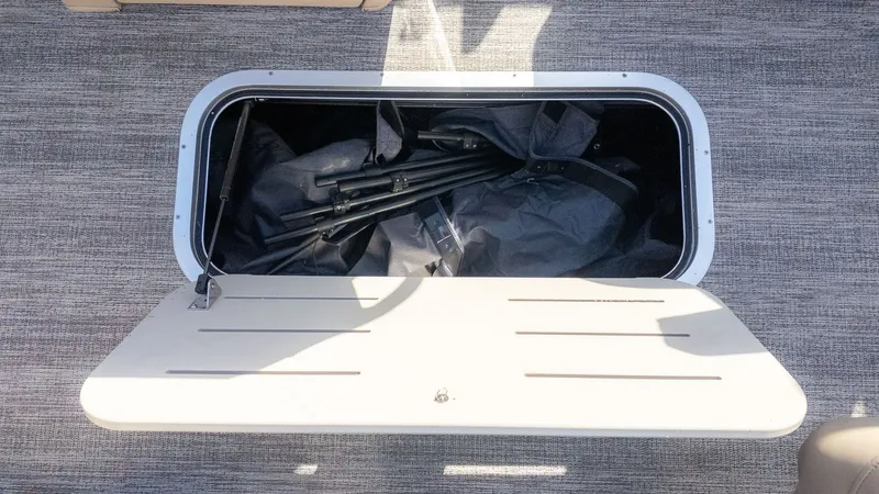 Slide: The Image of An open storage compartment with black items inside on a boat. - 17