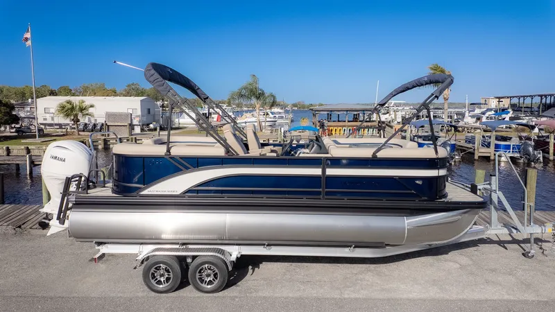 Slide: The Image of A Bennington 22 S STERN RADIUS pontoon boat on a trailer, parked at a marina. - 20