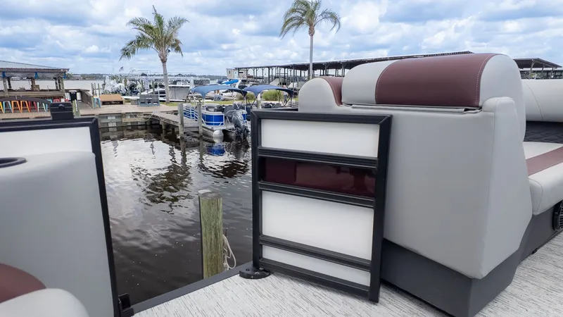 Slide: The Image of A modern pontoon boat with comfortable seating docked at a tranquil harbor with palm trees. - 8