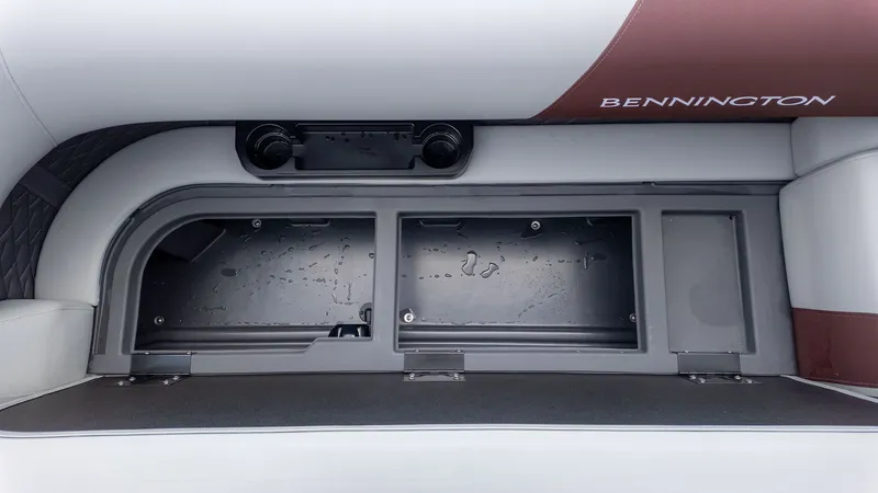 Slide: The Image of The image shows a storage compartment on a Bennington boat with cushioned seating. - 13