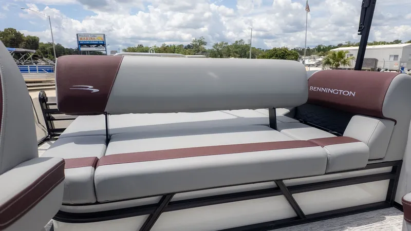 Slide: The Image of The image shows the seating area of a Bennington 22 S Swingback boat with gray and maroon upholstery. - 3