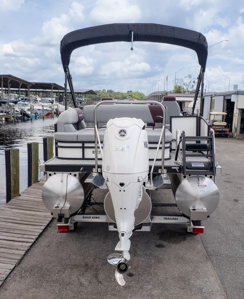 The Image of Bennington 22 S Swingback 2026 at dock with outboard motor and bimini top. - 1