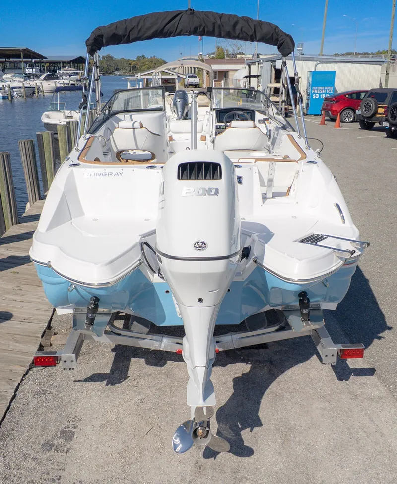 Slide: The Image of 2026 Stingray 231 DC on a trailer at the dock. Outboard motor and seating area visible. - 4
