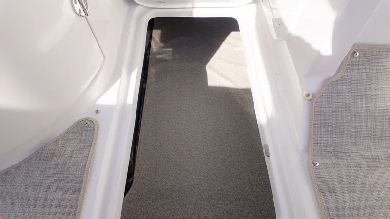 Slide: The Image of Interior view of a boat with gray carpet flooring and white walls. - 17