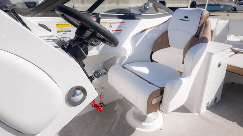 Slide: The Image of The image shows the cockpit of a Stingray 231 DC boat with a white and brown seat. - 22