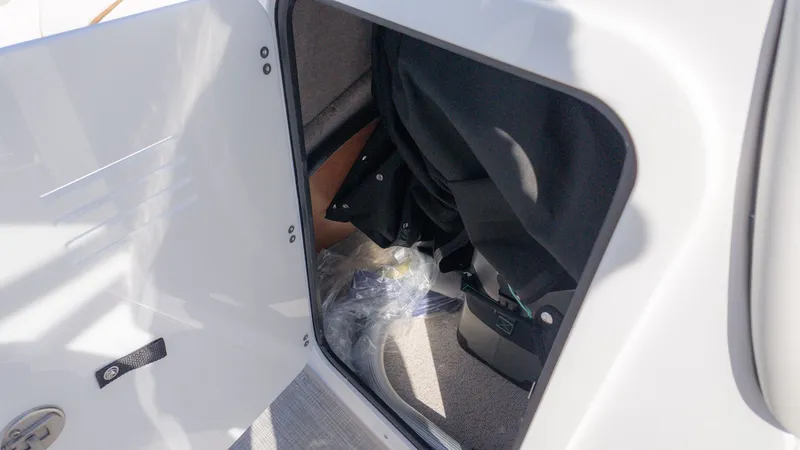 Slide: The Image of A storage compartment in the boat with a black cover and a plastic bag. - 21