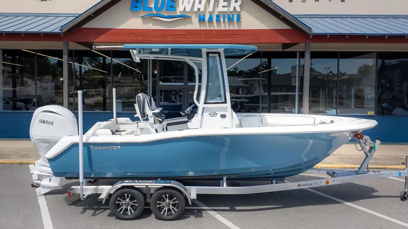 Slide: The Image of A blue and white 2027 Tidewater 210 LXF on a trailer in front of a boat building. - 19