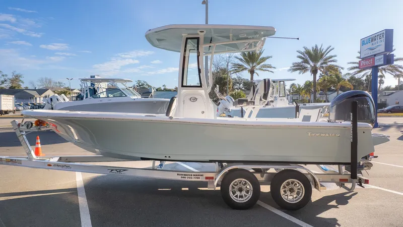 Slide: The Image of A Tidewater 2210 Carolina Bay boat on a trailer, parked in a lot under sunny weather. - 3