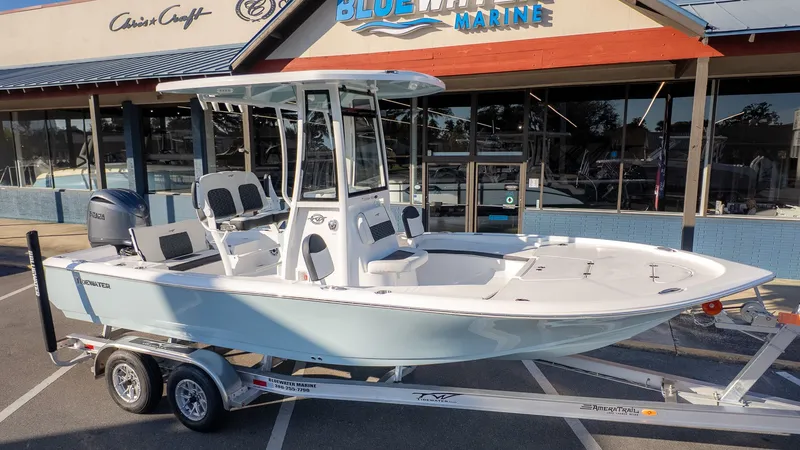 The Image of A 2026 Tidewater 2210 Carolina Bay boat on a trailer in front of a store. - 1