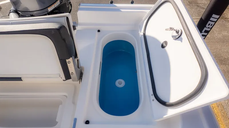 Slide: The Image of An open storage compartment on a boat with a blue interior and a water drain. - 7