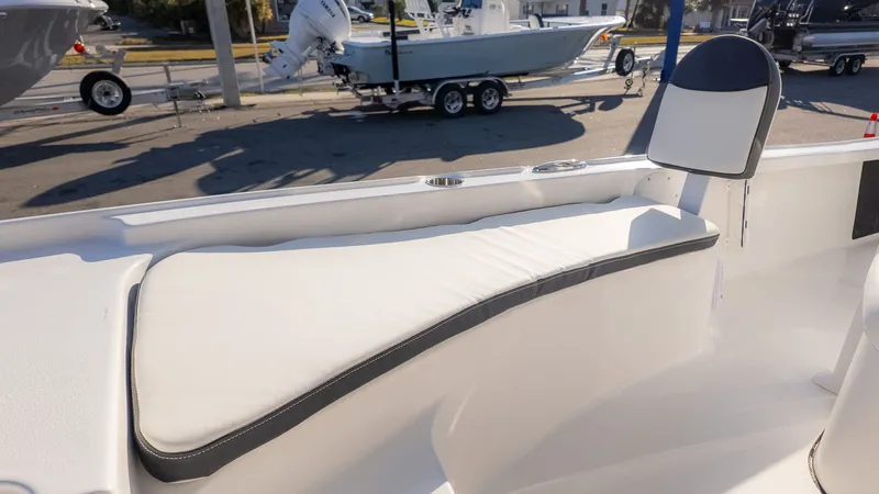Slide: The Image of The image shows a white bench seat on a boat, featuring a cushioned seat and backrest. - 15
