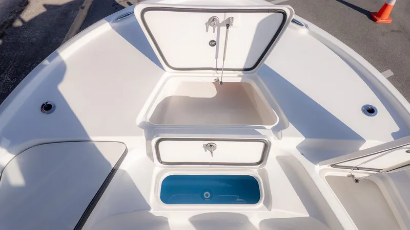 Slide: The Image of Tidewater 2210 Carolina Bay 2026: Open storage compartment and blue insert on the deck. - 17