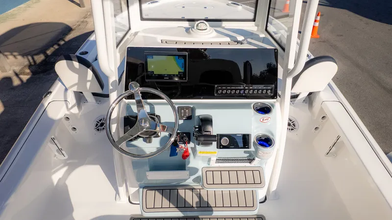 Slide: The Image of The image shows the helm of a Tidewater 2210 Carolina Bay boat. It features a modern design with a large screen, steering wheel, and various controls. - 9