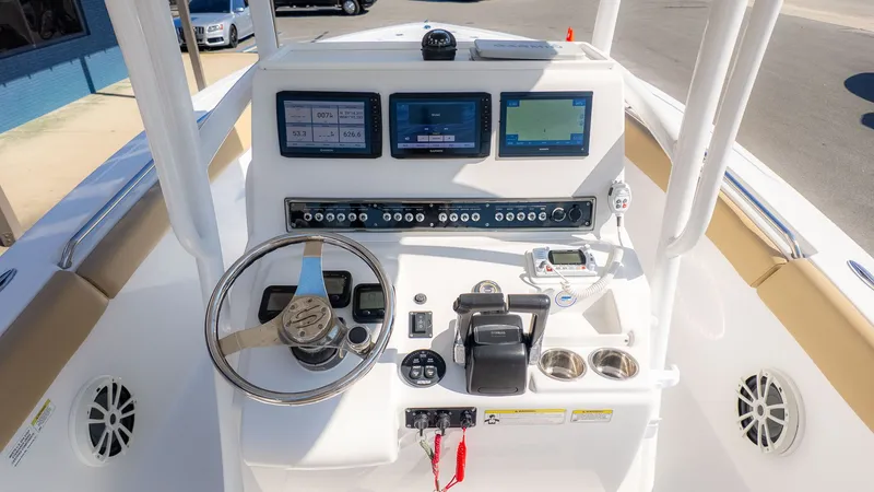 Slide: The Image of The image shows the helm of a 2014 Sportsman 251 Heritage boat with multiple screens and controls. - 14