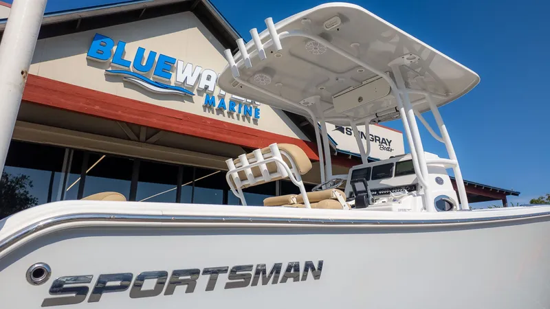 The Image of A Sportsman 251 Heritage boat in front of a building with a "Bluewater Marine" sign. - 1