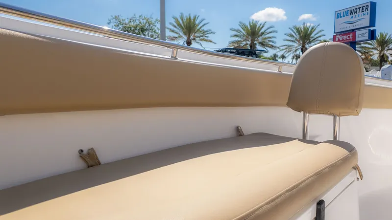 Slide: The Image of Close-up of a beige bench seat on a boat, surrounded by palm trees and blue sky. - 20