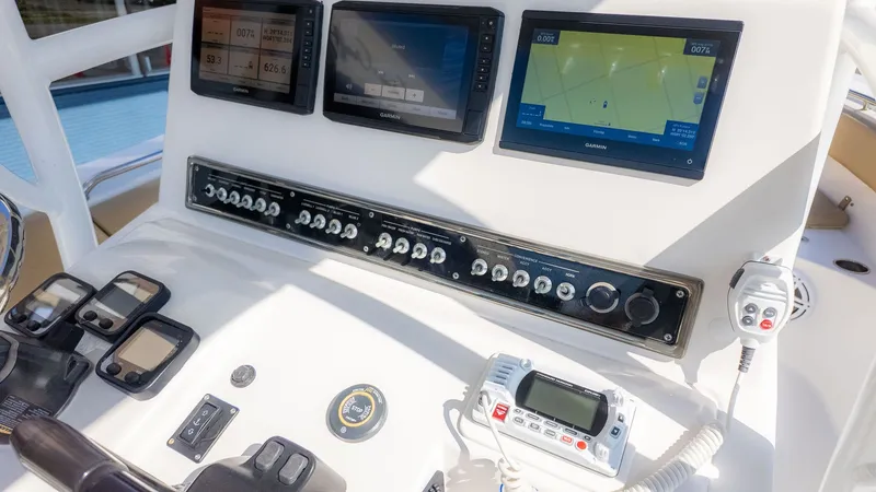 Slide: The Image of The image shows the helm of a Sportsman 251 Heritage boat with multiple screens and controls. - 14