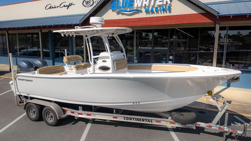 The Image of A white sport boat on a trailer in front of a store. - 1