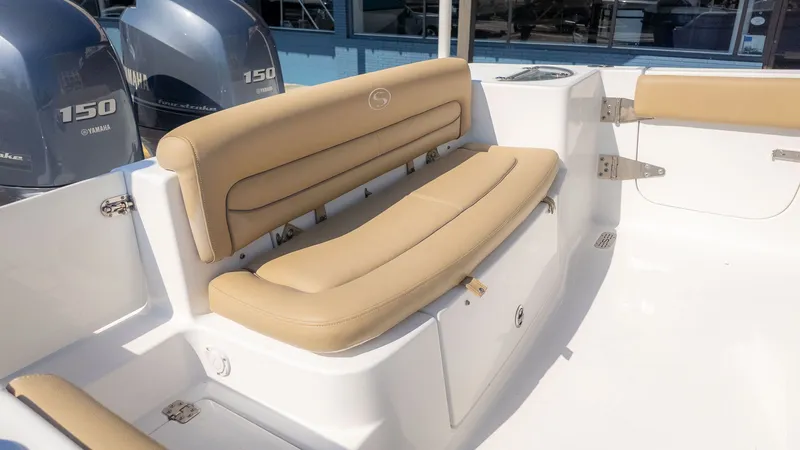 Slide: The Image of The image shows the seating area of a 2014 Sportsman 251 Heritage boat with beige cushions. - 7