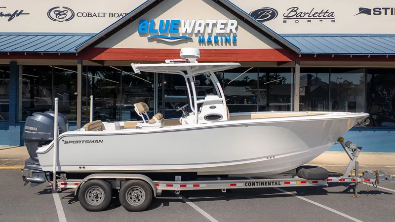 Slide: The Image of A 2014 Sportsman 251 Heritage boat on a trailer in front of a marine store. - 21