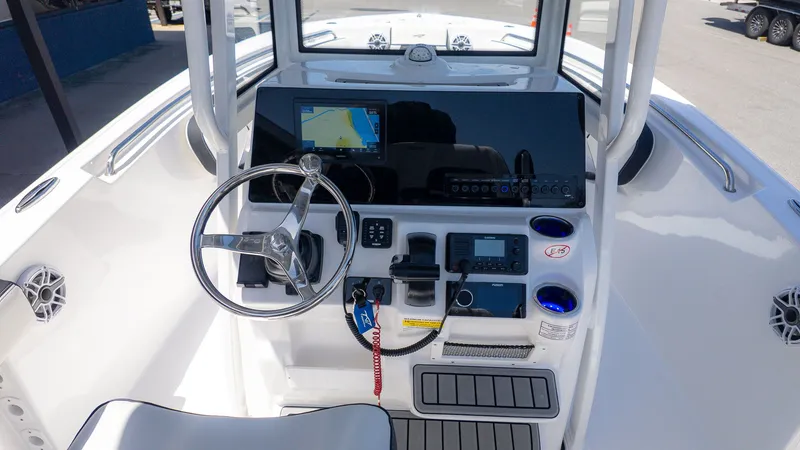 Slide: The Image of The image shows the helm of a Tidewater 220 CC Adventure boat. It features a modern navigation system, steering wheel, and various controls. - 14