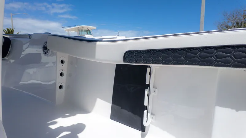 Slide: The Image of Interior view of a boat with white hull and black padding. Blue sky in the background. - 16