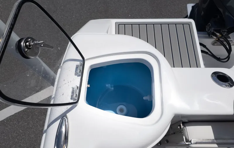 Slide: The Image of The image shows the cockpit of a Tidewater 220 CC Adventure boat with an open storage compartment. - 3
