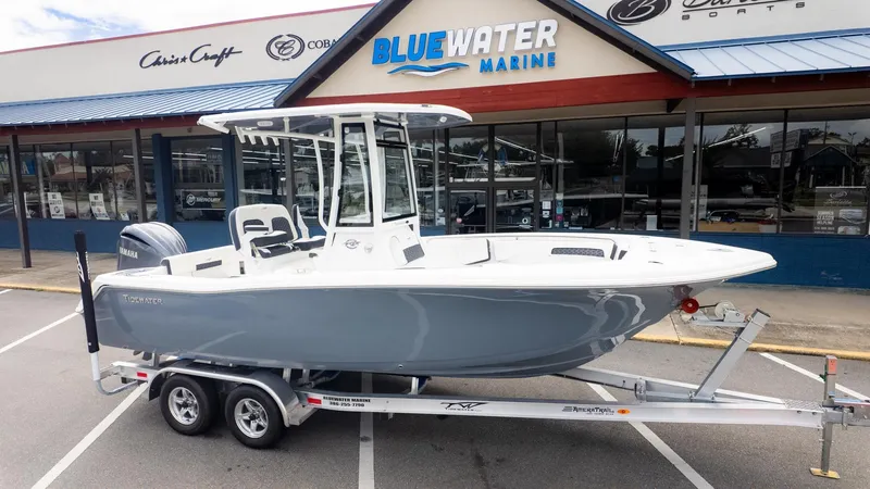 The Image of Tidewater 220 CC Adventure 2026 on a trailer in front of a boat dealership. - 1