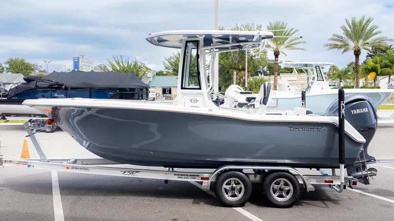 The Image of A gray Tidewater 220 CC Adventure boat on a trailer, parked in a lot. - 1