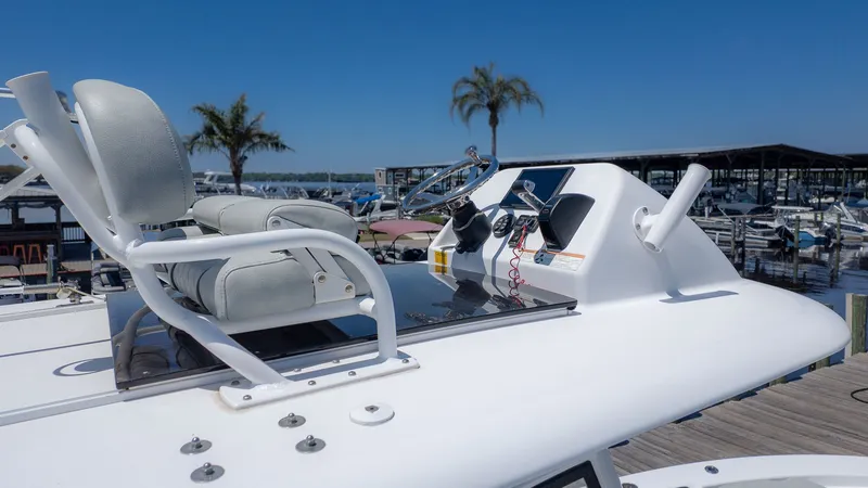 Slide: The Image of The image shows the helm of a 2019 Sportsman Masters 267 Bay Boat with gray seats. - 23