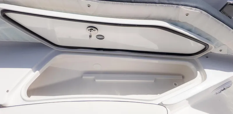 Slide: The Image of Storage compartment on a Tidewater 232 LXF boat, featuring an open hatch and cushioning. - 16