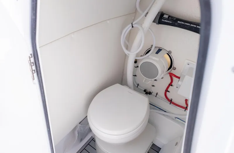Slide: The Image of The image shows a clean, white boat toilet with technical fittings on the wall. - 19