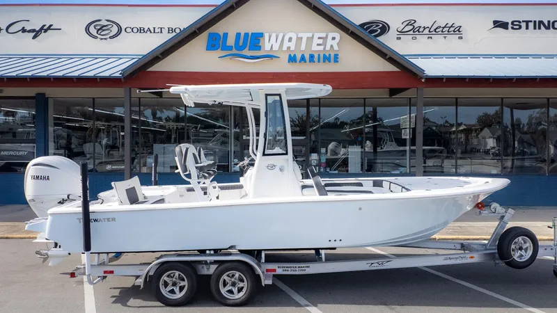 Slide: The Image of A white Tidewater 2300 Carolina Bay boat on a trailer in front of a boat dealership. - 26