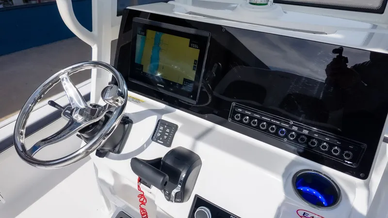 Slide: The Image of The image shows a boat's helm with a large screen and steering wheel. - 12