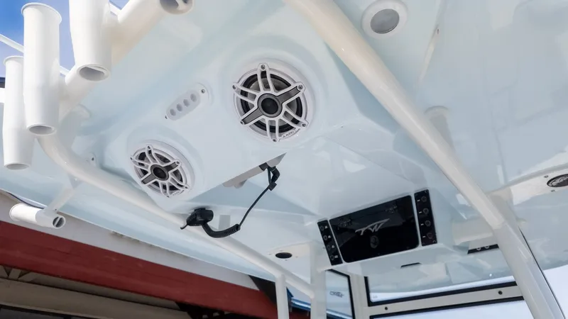 Slide: The Image of The image shows a boat's ceiling with speakers and fishing rod holders. - 8