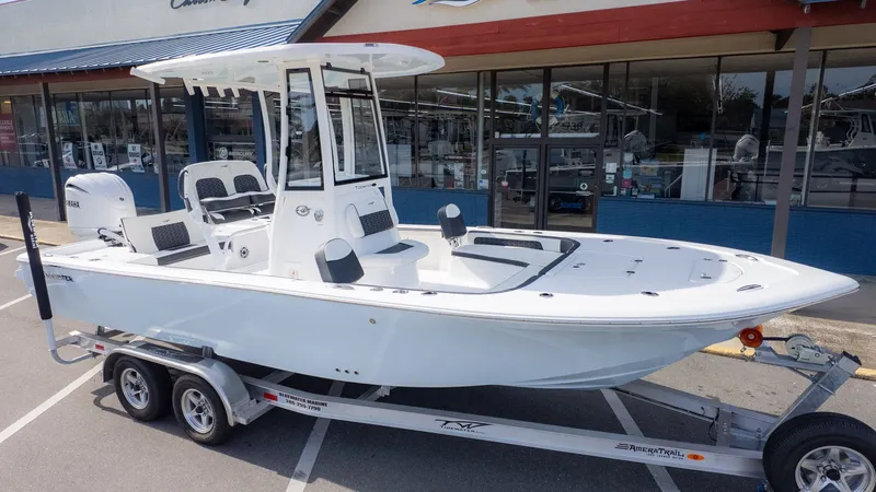Slide: The Image of A white Tidewater 2300 Carolina Bay boat on a trailer in front of a store. - 26